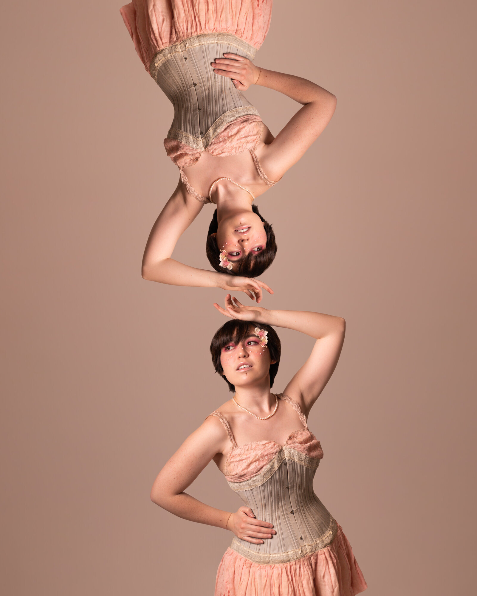 Image of a person with one hand on their hip and the other over their head with the same image reflected above them