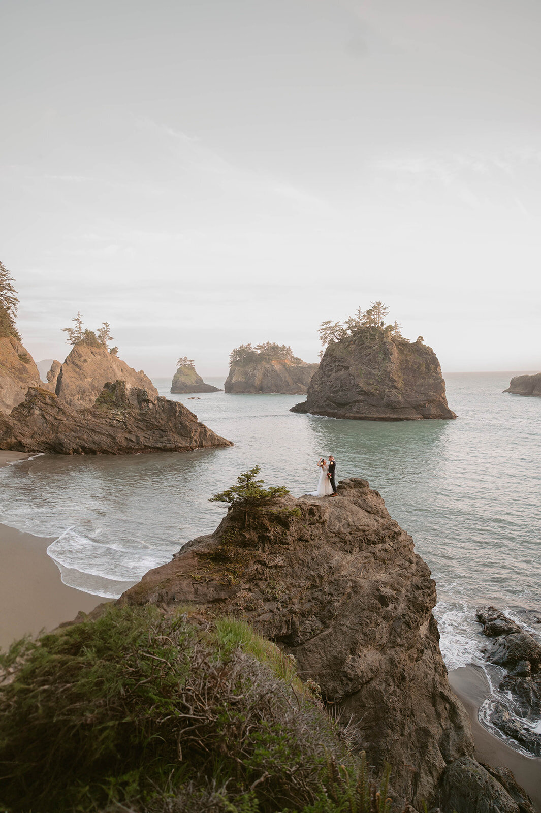 Couple stand on the rock at the coastal