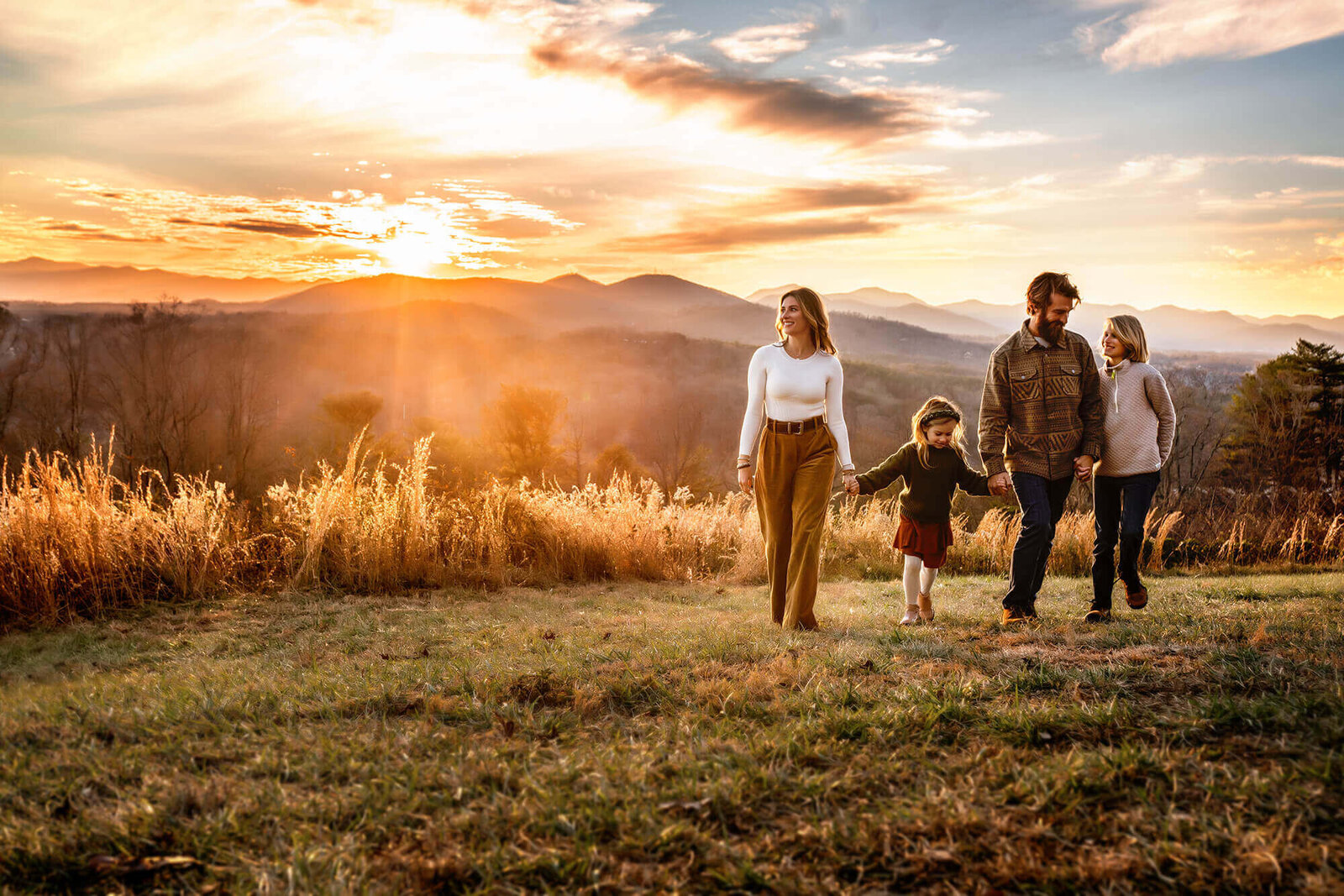 A family strolling a mountain top at sunset in Asheville North Carolina