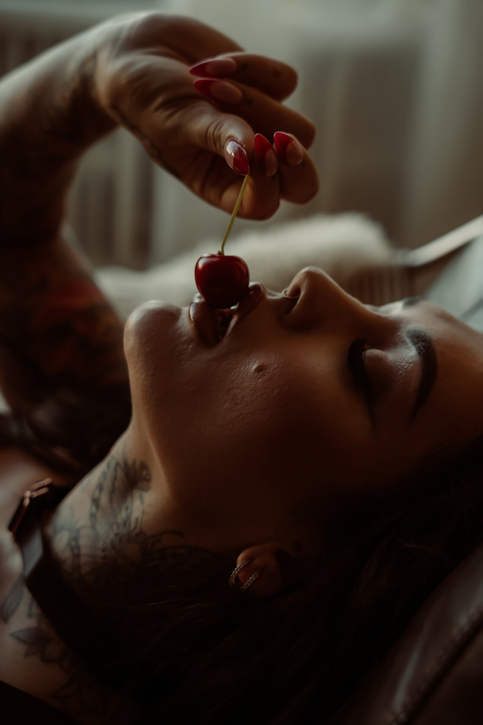 sensual photo of woman grazing a cherry on her lips