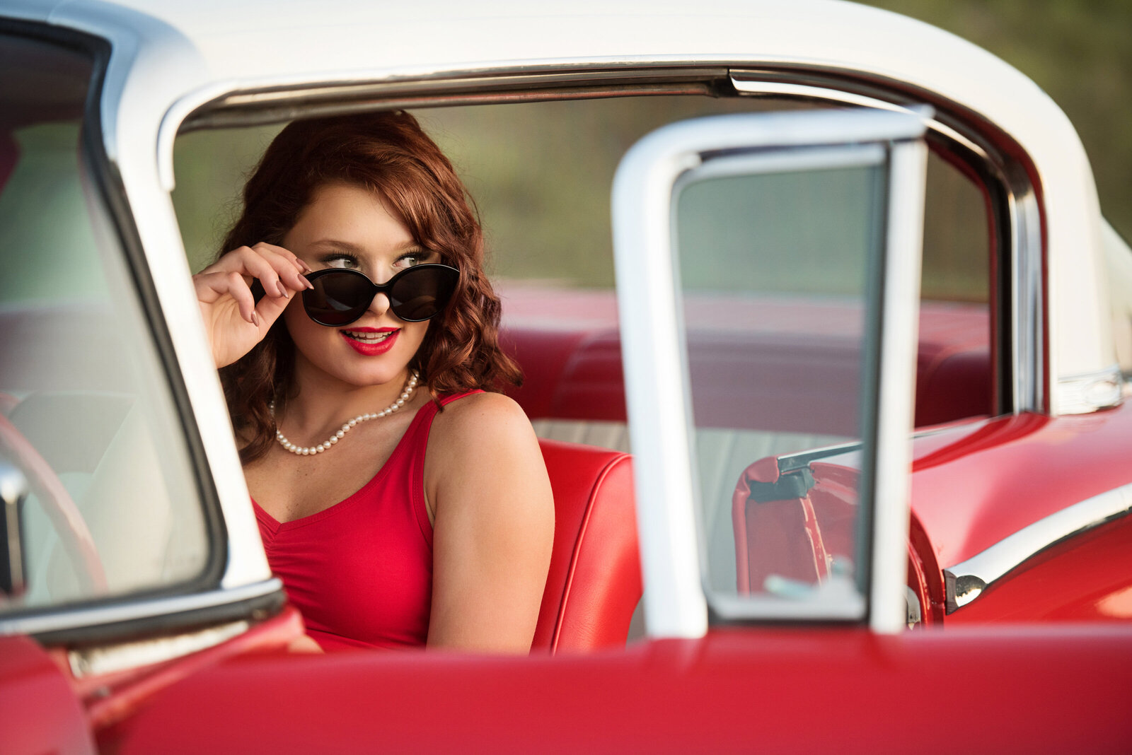 Blaine Minnesota high school senior picture of girl in vintage red car with sunglasses