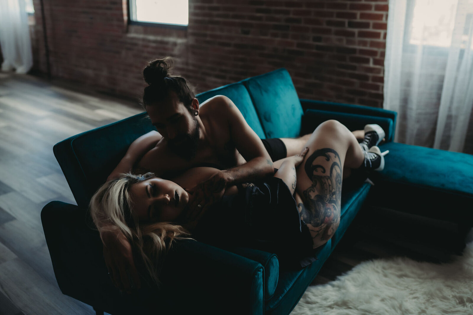intimate boudoir couple's image of woman and man on green couch