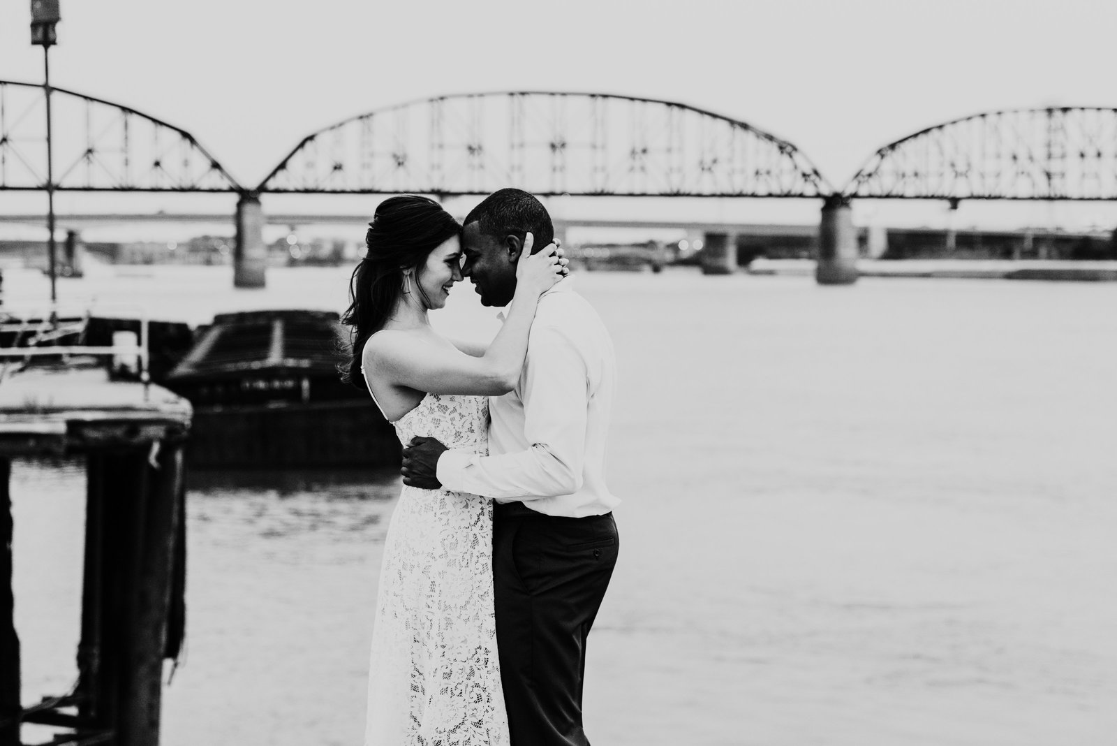couple hugging in front of bridge during engagement photos