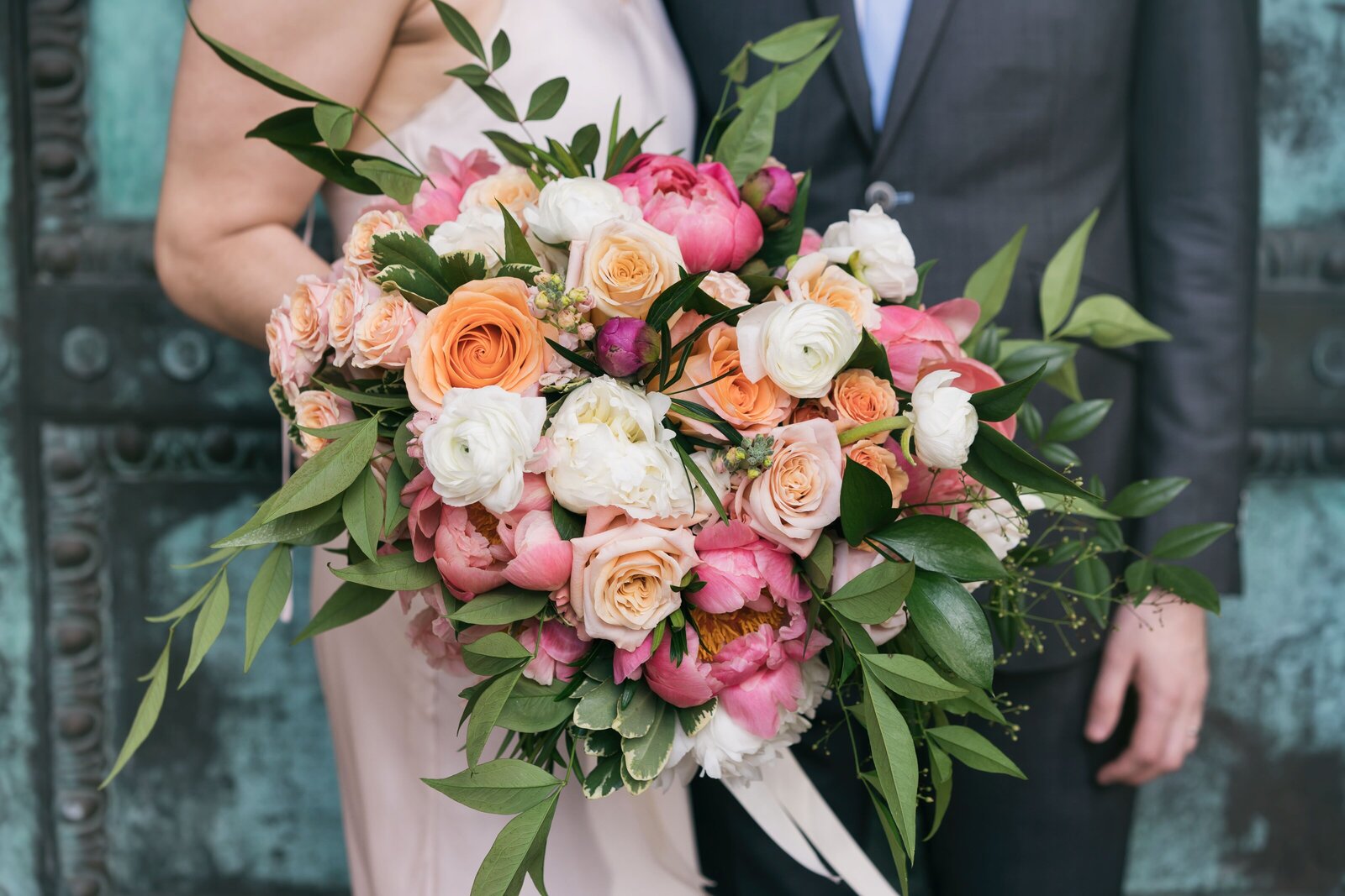 close up of bride and groom holding bouquet