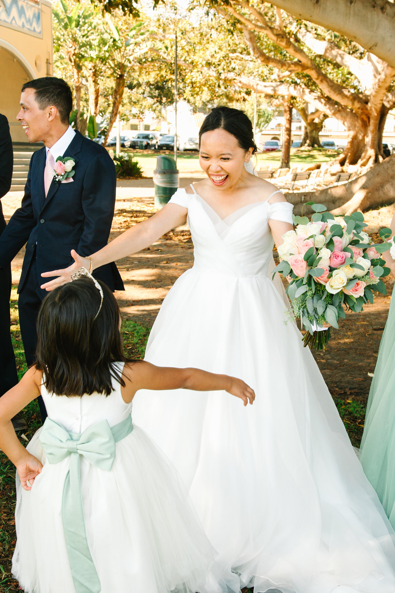 A happy bride greets her flower girl after her wedding ceremony.