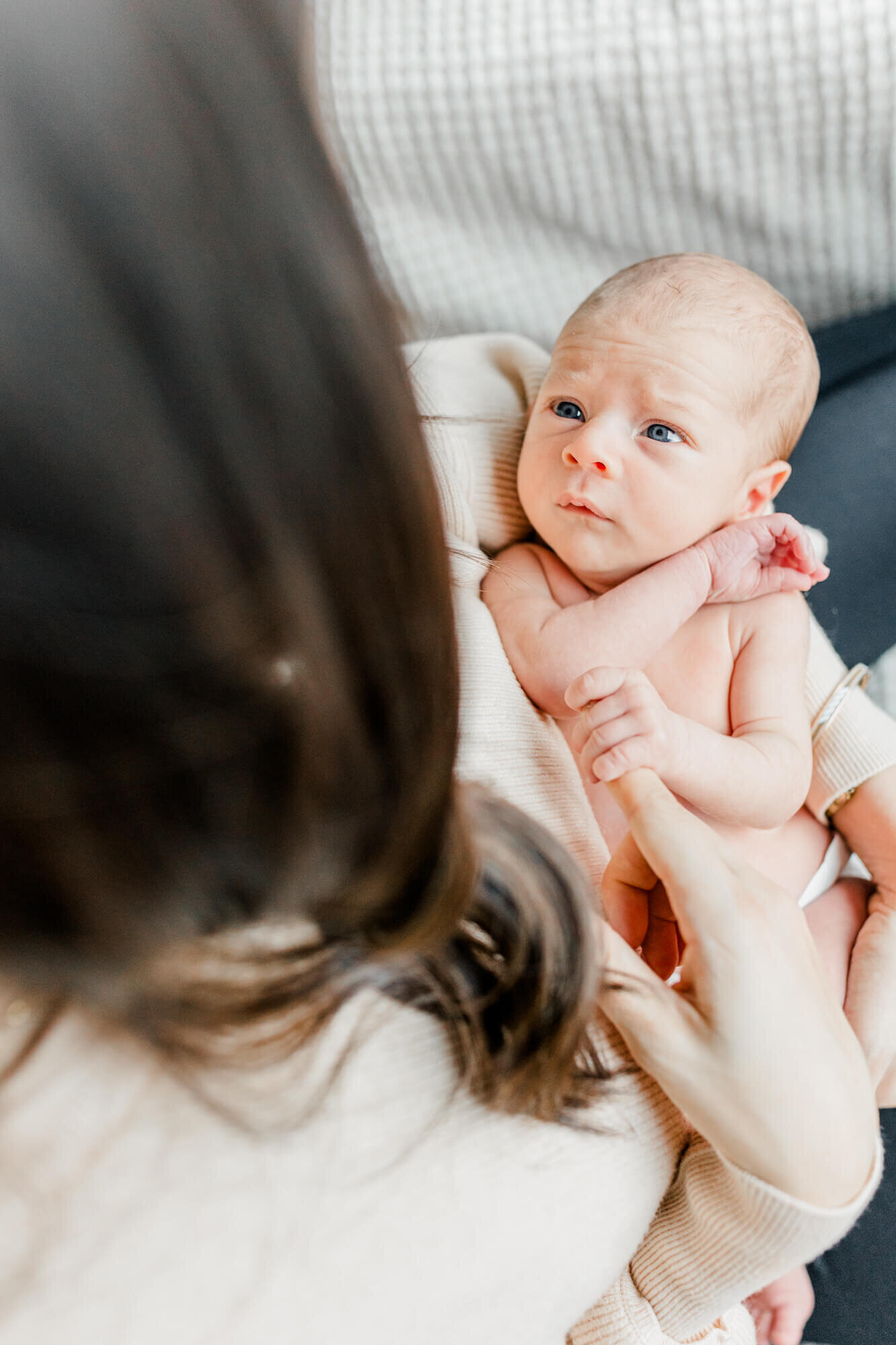 With a viewpoint from over mom's shoulder,  baby looks up at his mom