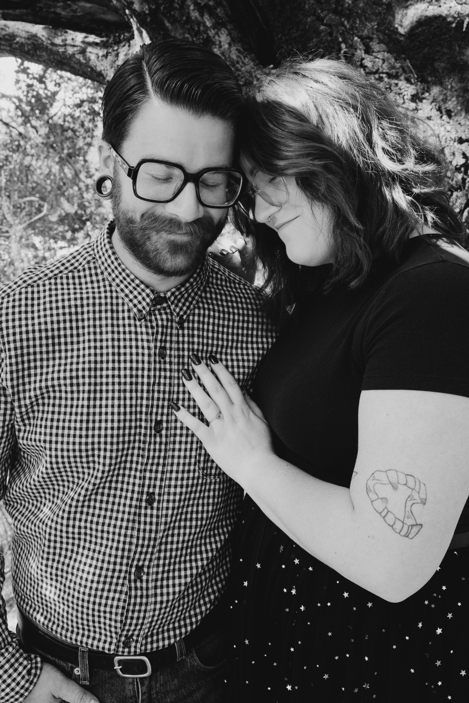 An tattooed engaged couple poses for photos in a redwood forest in Santa Cruz, Ca.