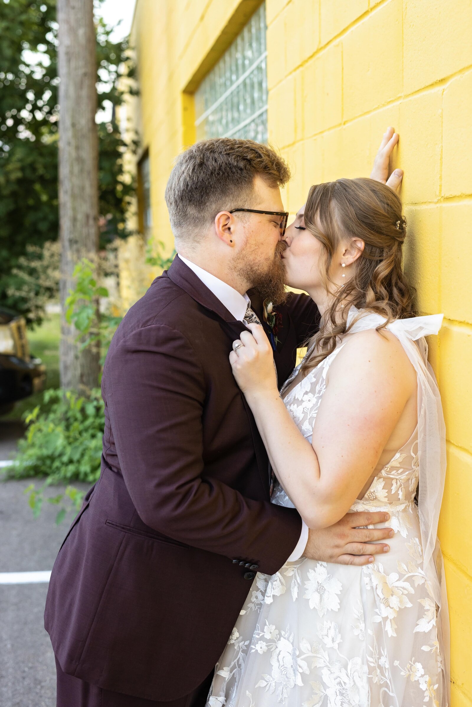 couple-kissing-against-yellow-wall-minneapolis