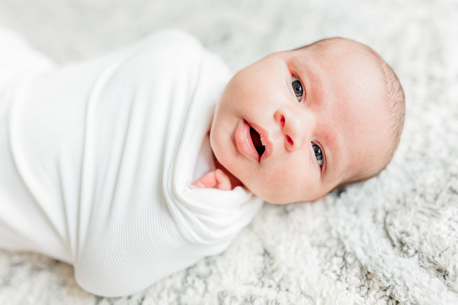 Newborn looks at the camera with an interested expression