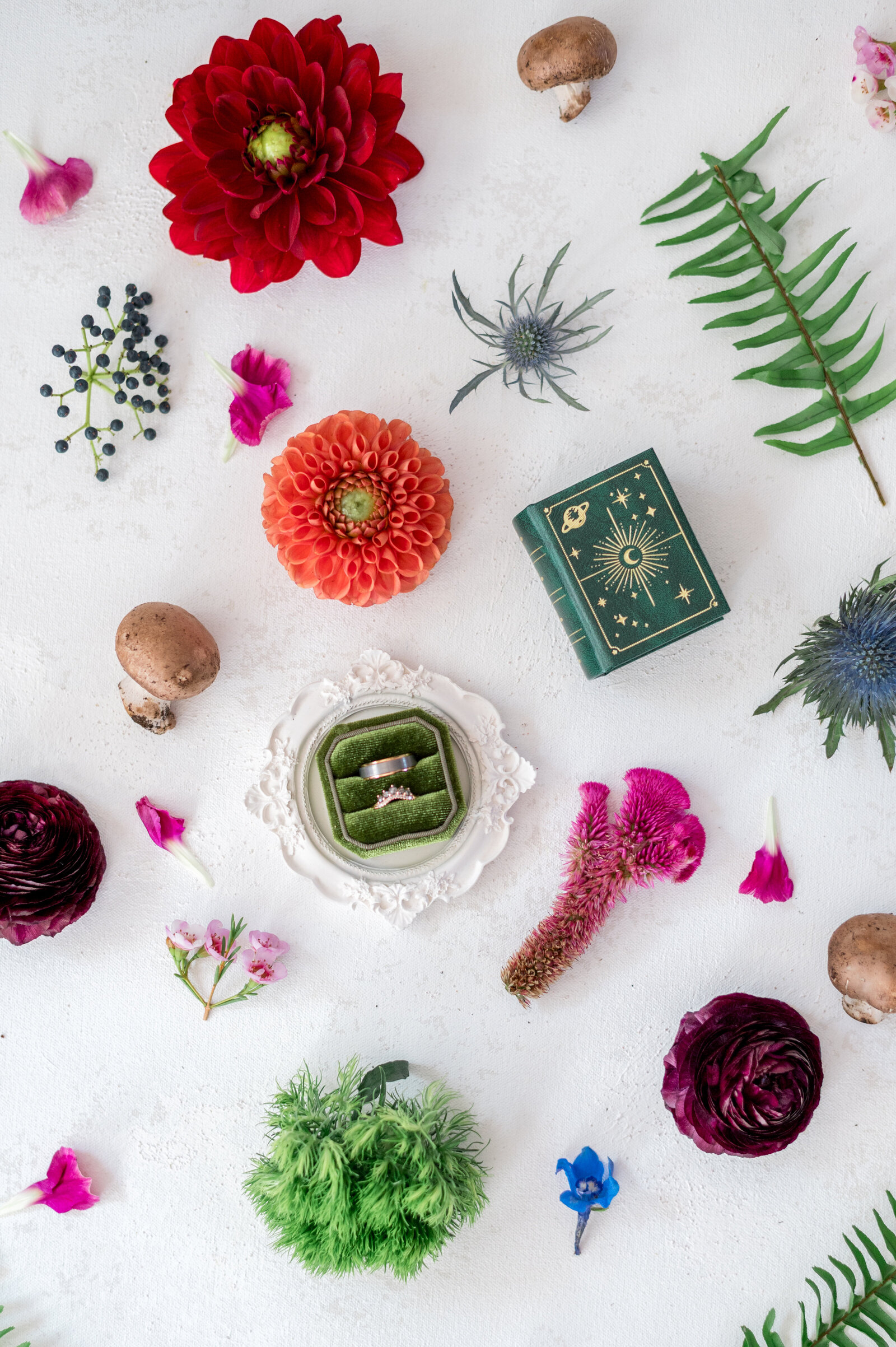 Colorful wedding flatlay with floral details, greenery, and heirloom ring box — luxury detail photography by Sarah Surette Photography.