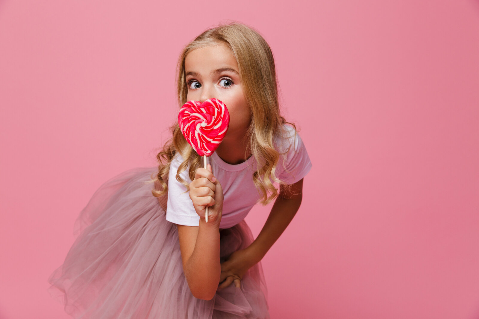 portrait-pretty-little-girl-holding-heart-shaped-lollipop