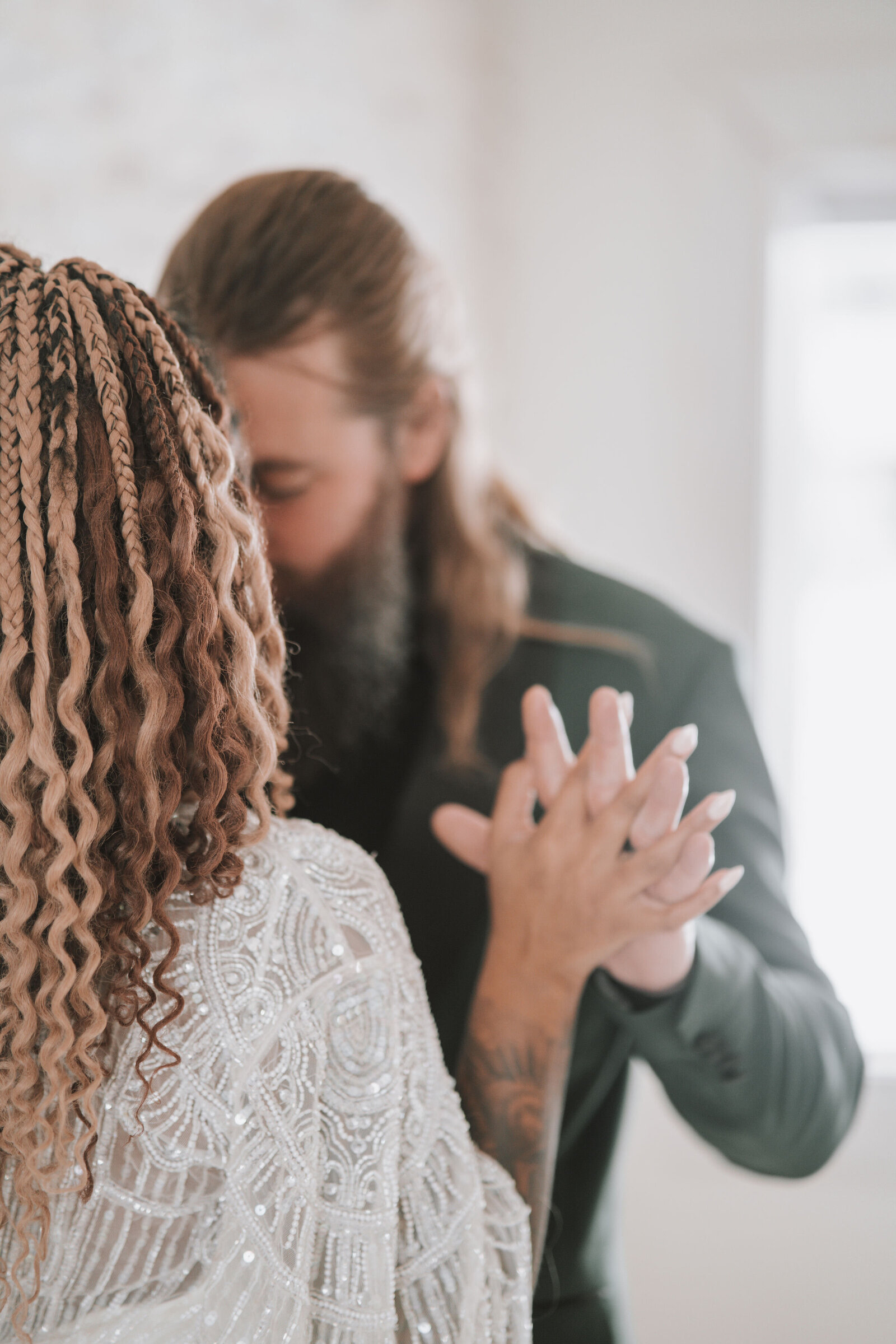 Bride and Groom interlock fingers while kissingg surrounded by bright light captured by  Idaho Falls Wedding Photographer