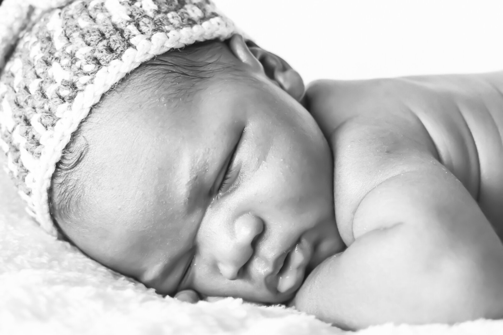 black and white photo of a newborn baby sleeping during his photoshoot photographed by Millz Photography in Greenville, SC