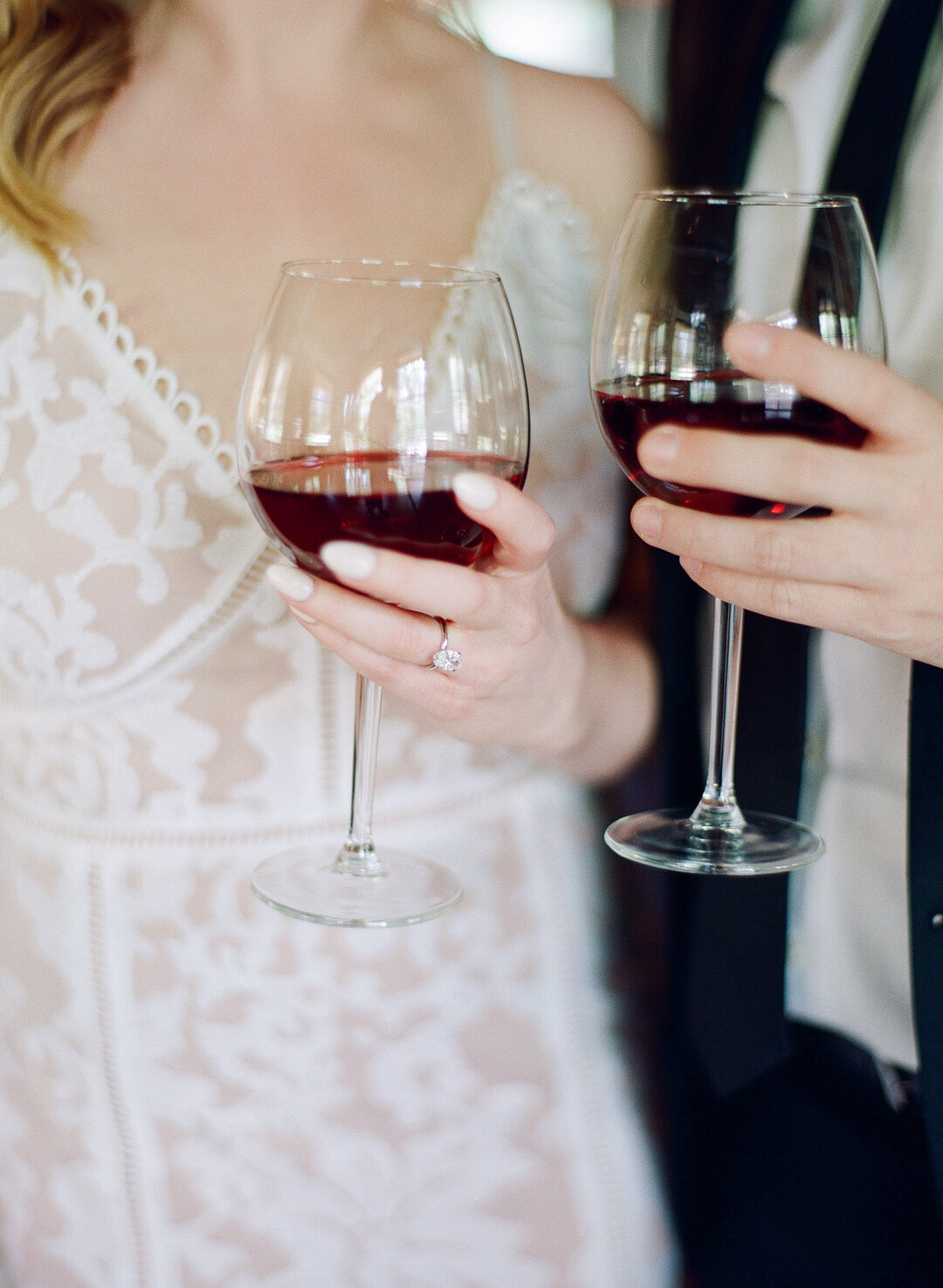 Bride and Groom Holding glasses of red wine