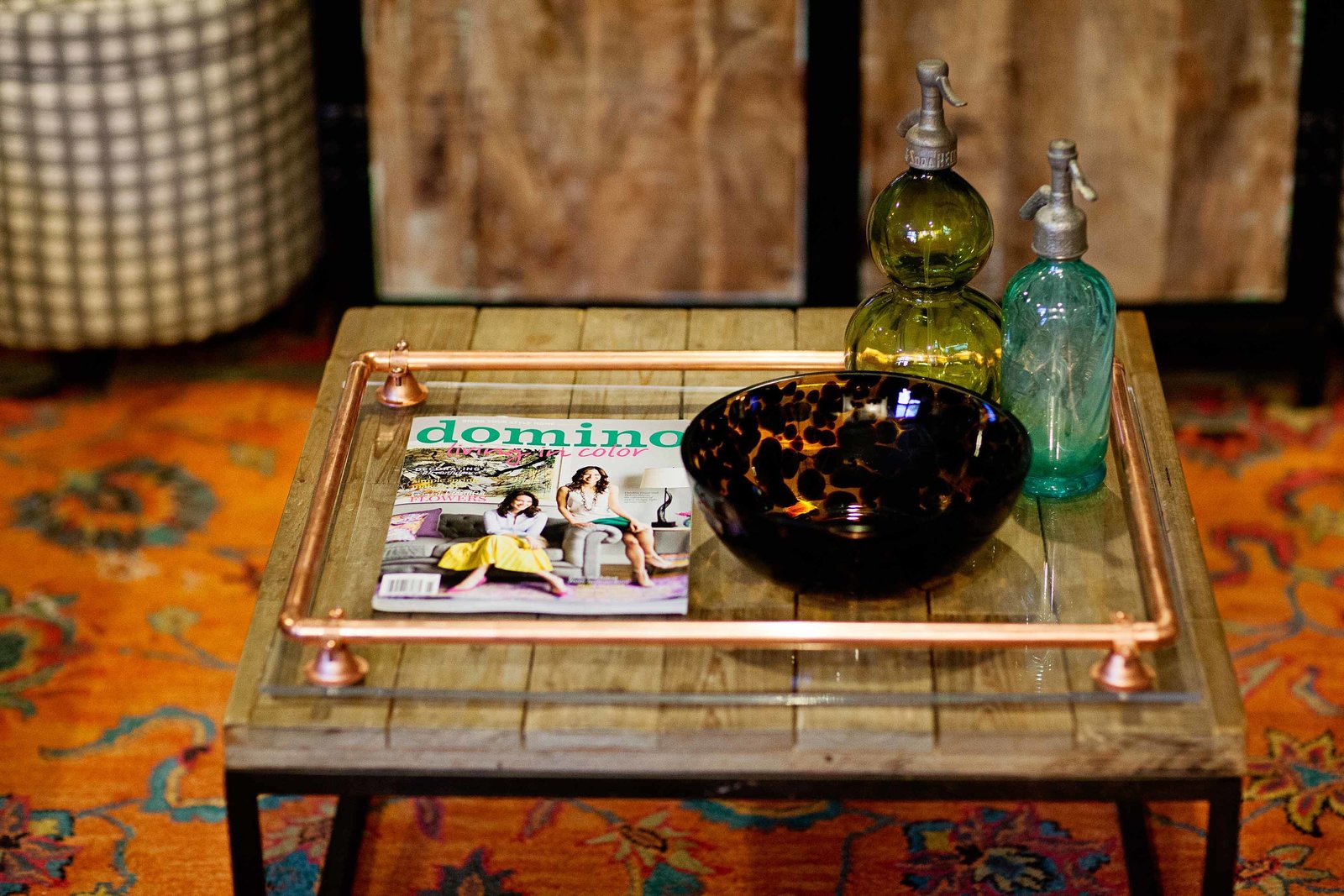 A coffee table with glass dishes and a domino magazine.