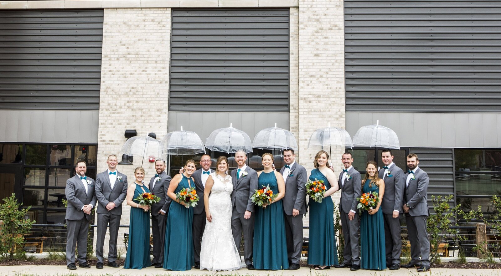 Wedding party holding umbrellas