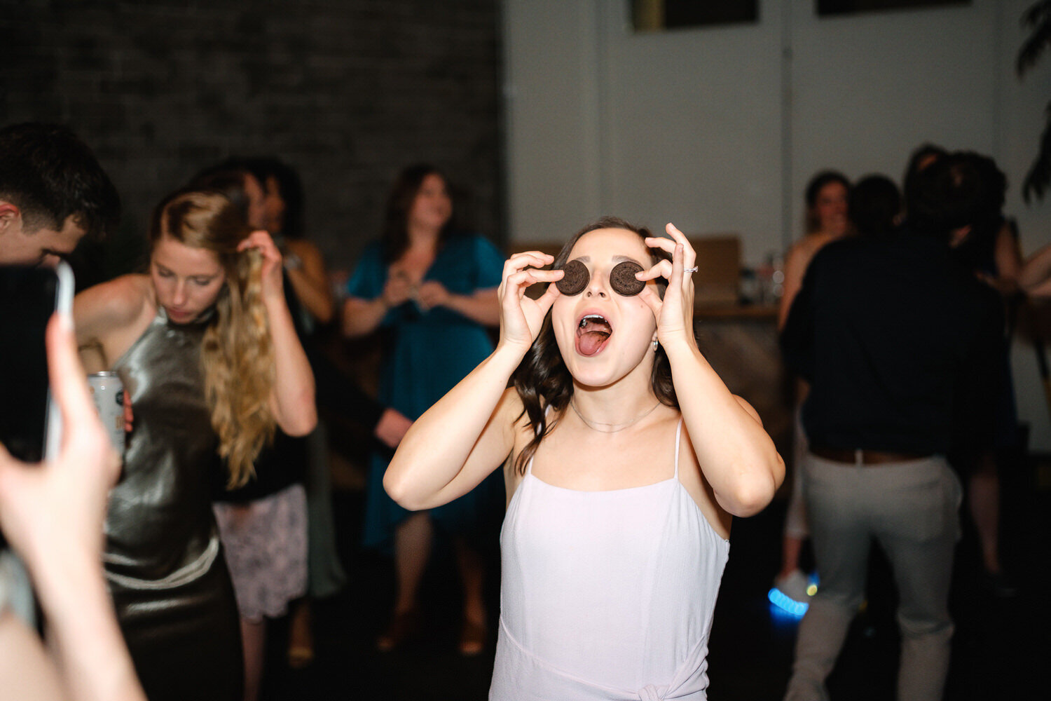 Bridesmaid holds oreos over her eyes while on the dance floor
