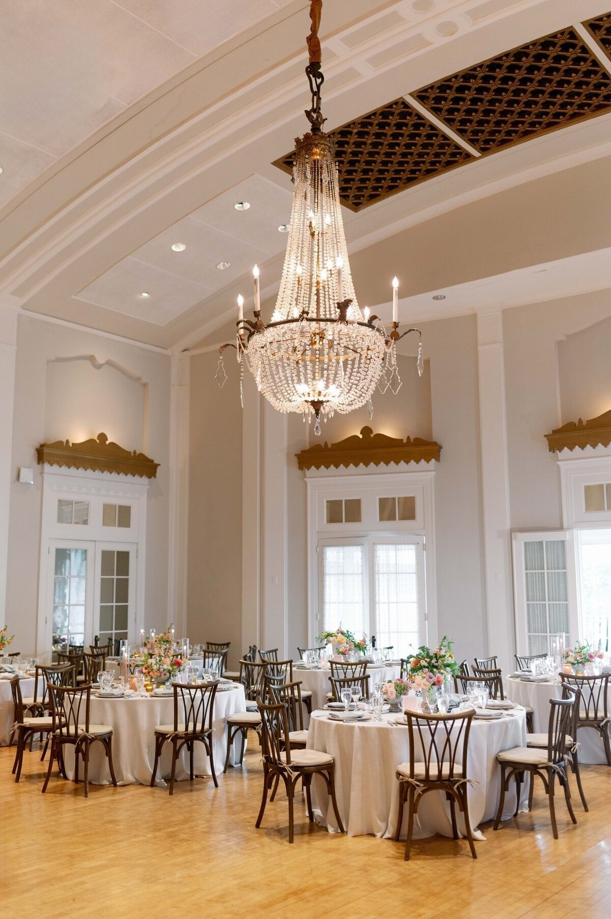 ornate chandelier and set tables and chairs in reception hall for minneapolis minnesota wedding photographed by bauer creative