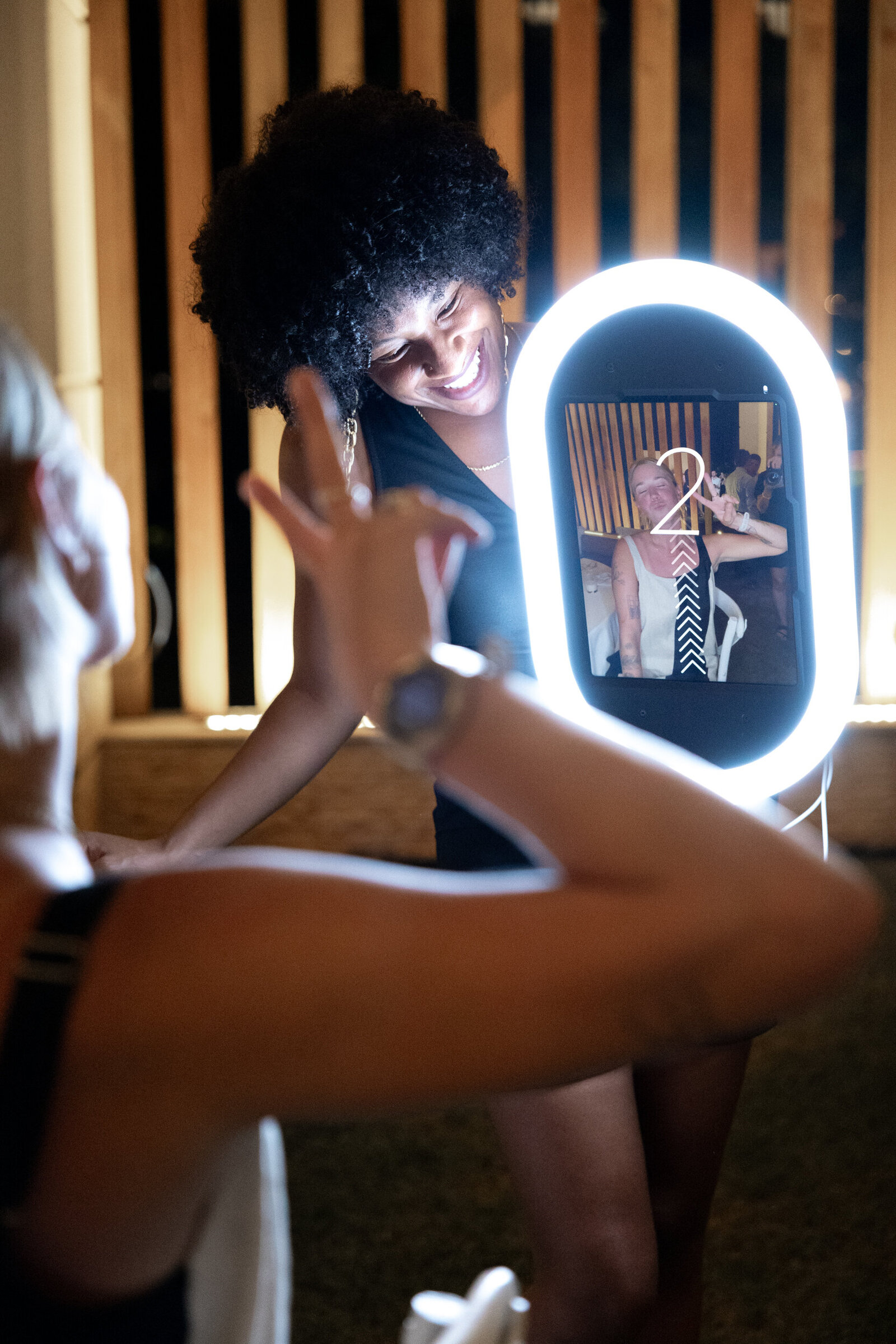 Photo booth attendant using the handheld roamer booth to capture candid guest moments on the dance floor
