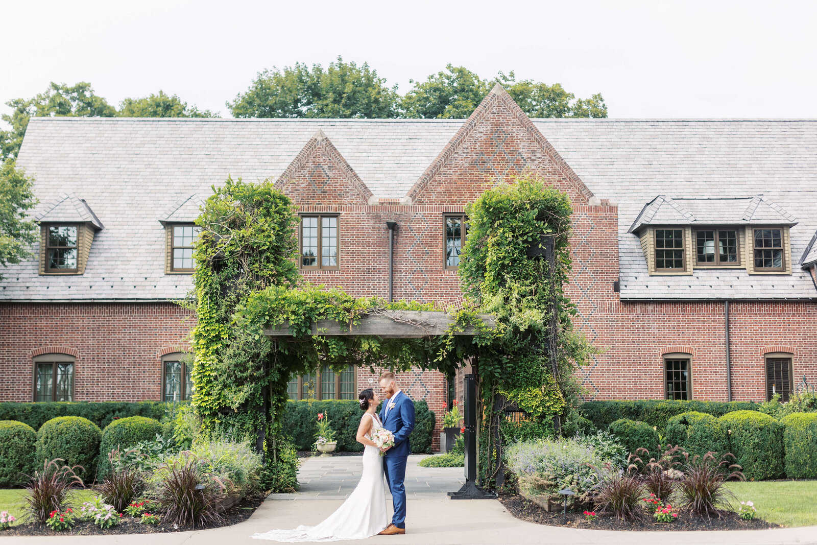 Wide angle shot of bride and groom in front of their NJ wedding venue.