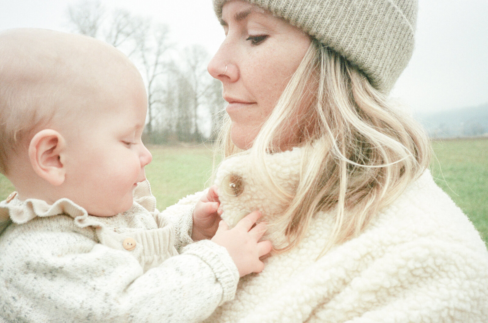 Baby girl playing with mothers hair on Sauvie Island in Portland, Oregon.