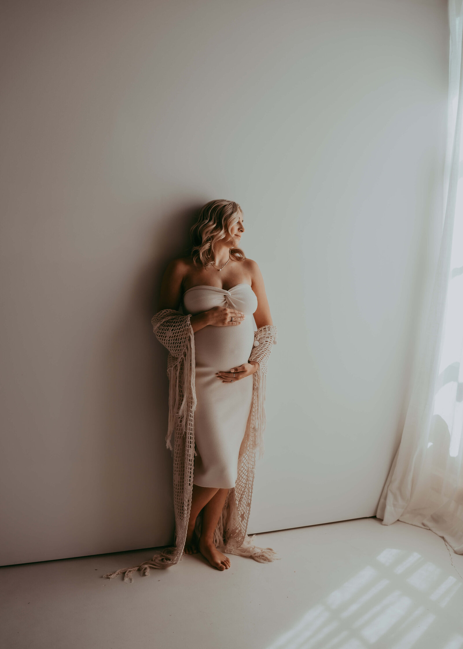 gorgeous pregnant mom looks out window