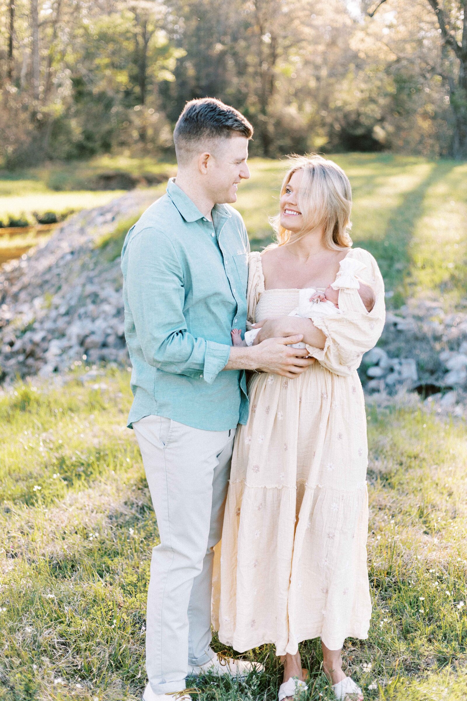 parents smiling at each other during newborn session in peoria illinois