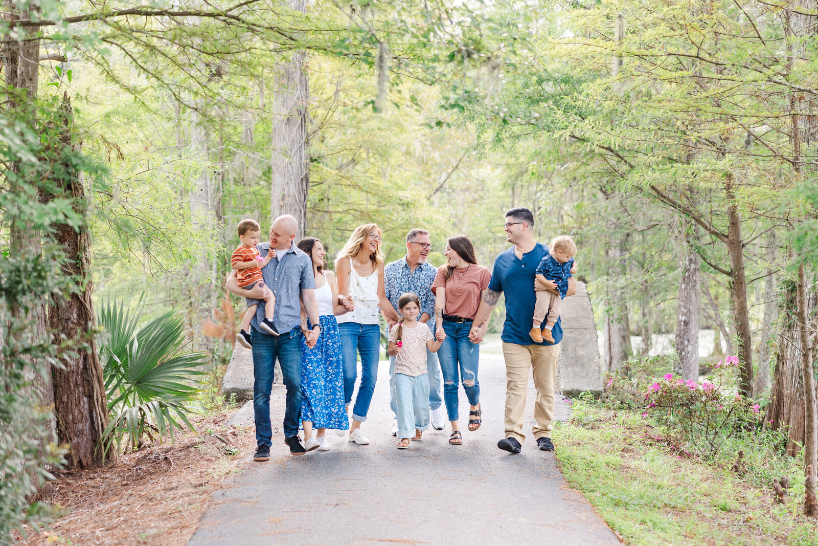 Large extended family holding hands and laughing at Cypress Gardens, sc