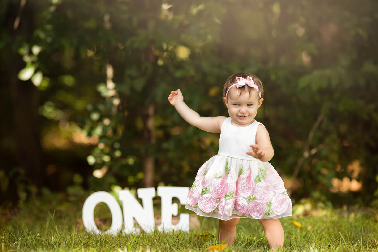 One year old girl in front of white letters spelling one