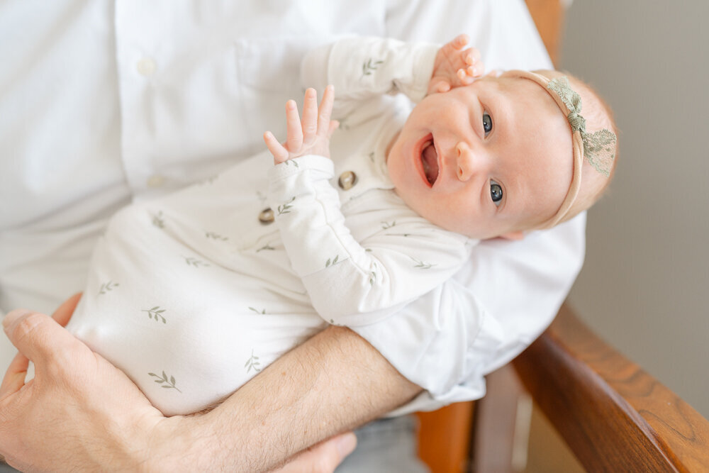 baby girl smiling while held in McLean, Virginia