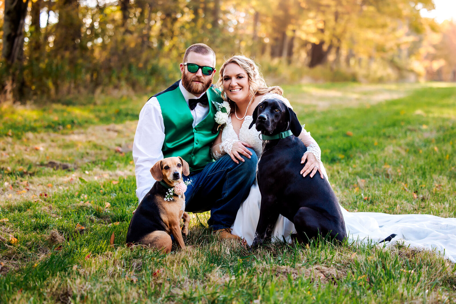 Newly wed couple poses with their two  dogs for a family photo