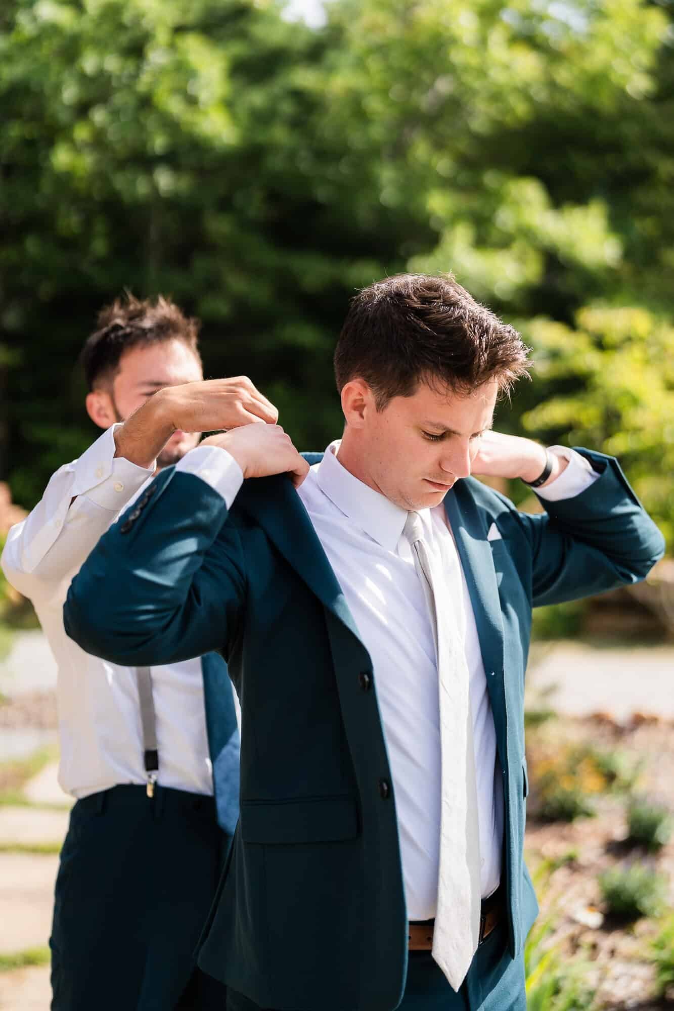 Best man helping the groom getting ready at terra incognita vineyard wedding in the North Georgia mountains