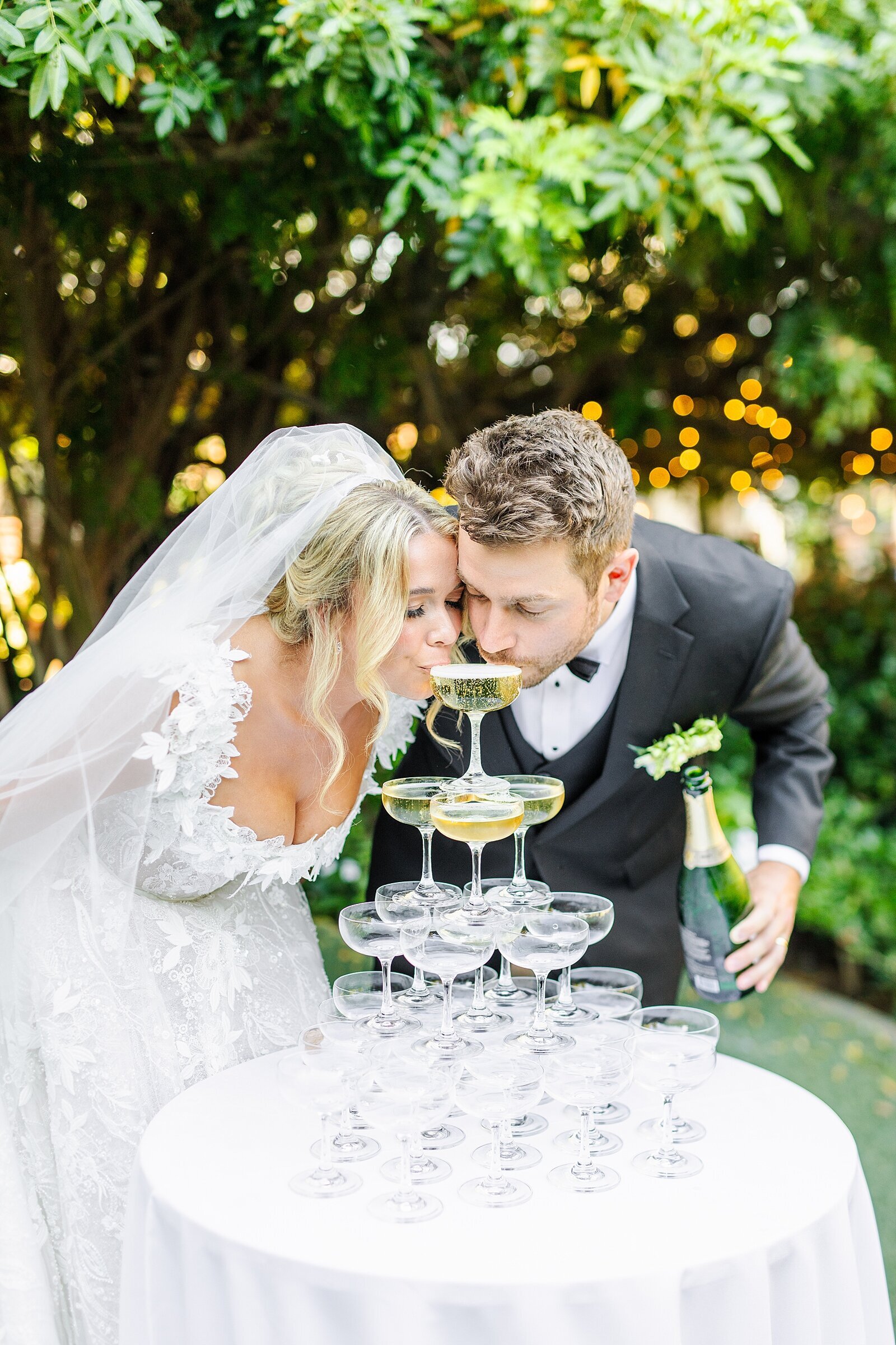 Bride and groom sipping from champagne tower at Green Gables Wedding Estate in San Marcos.