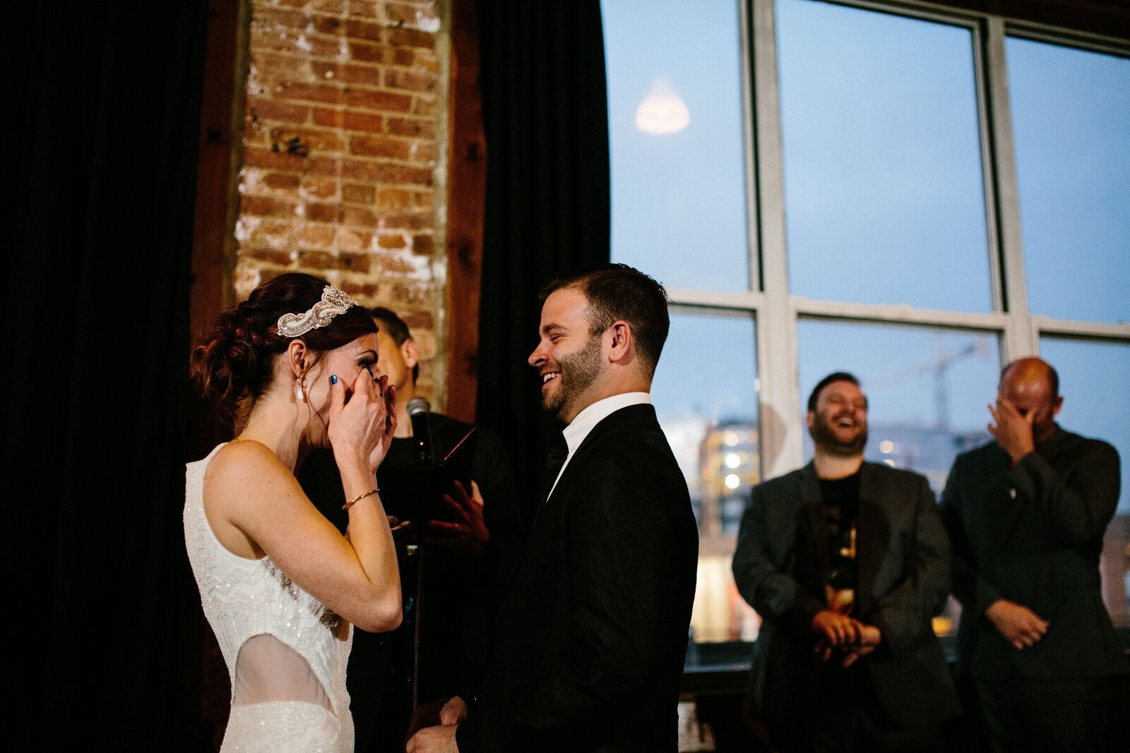 Bride wipes away happy tears during wedding ceremony