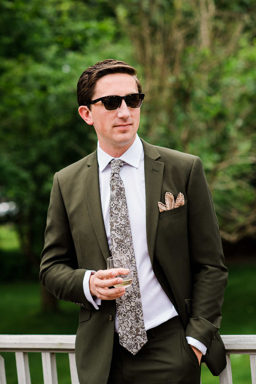 groom in sunglasses with glass of wine