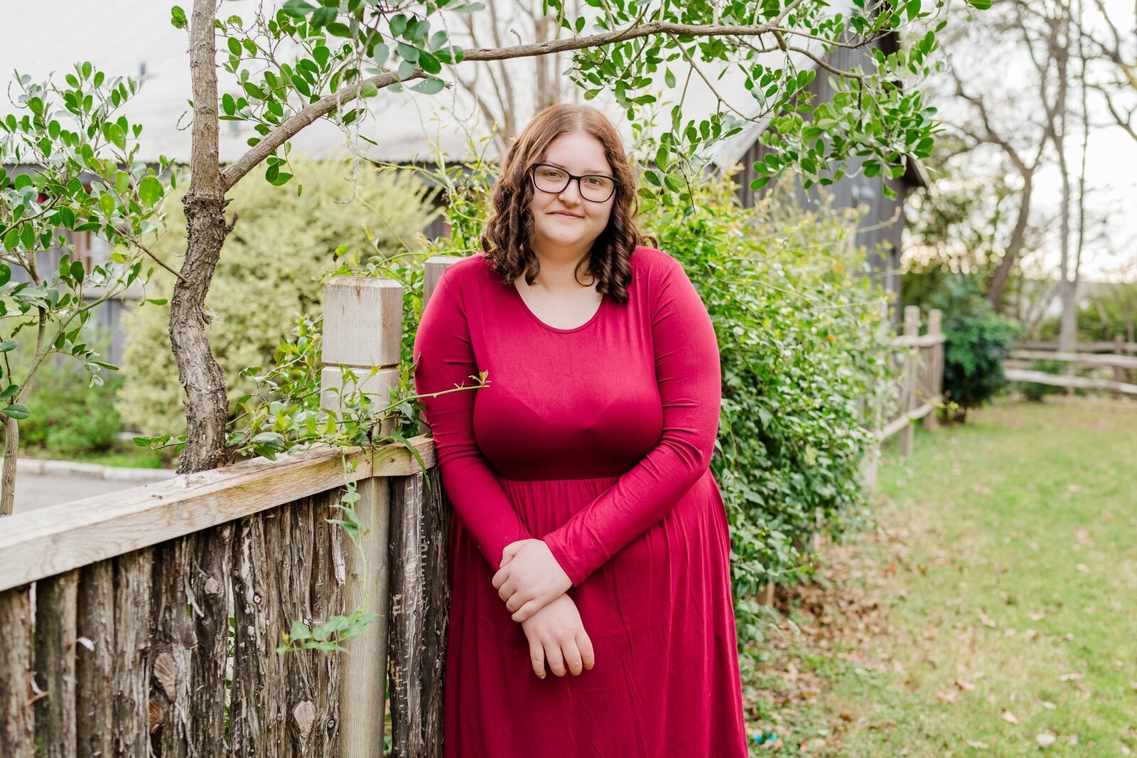 Canyon High School senior girl leaning on fence in Gruene
