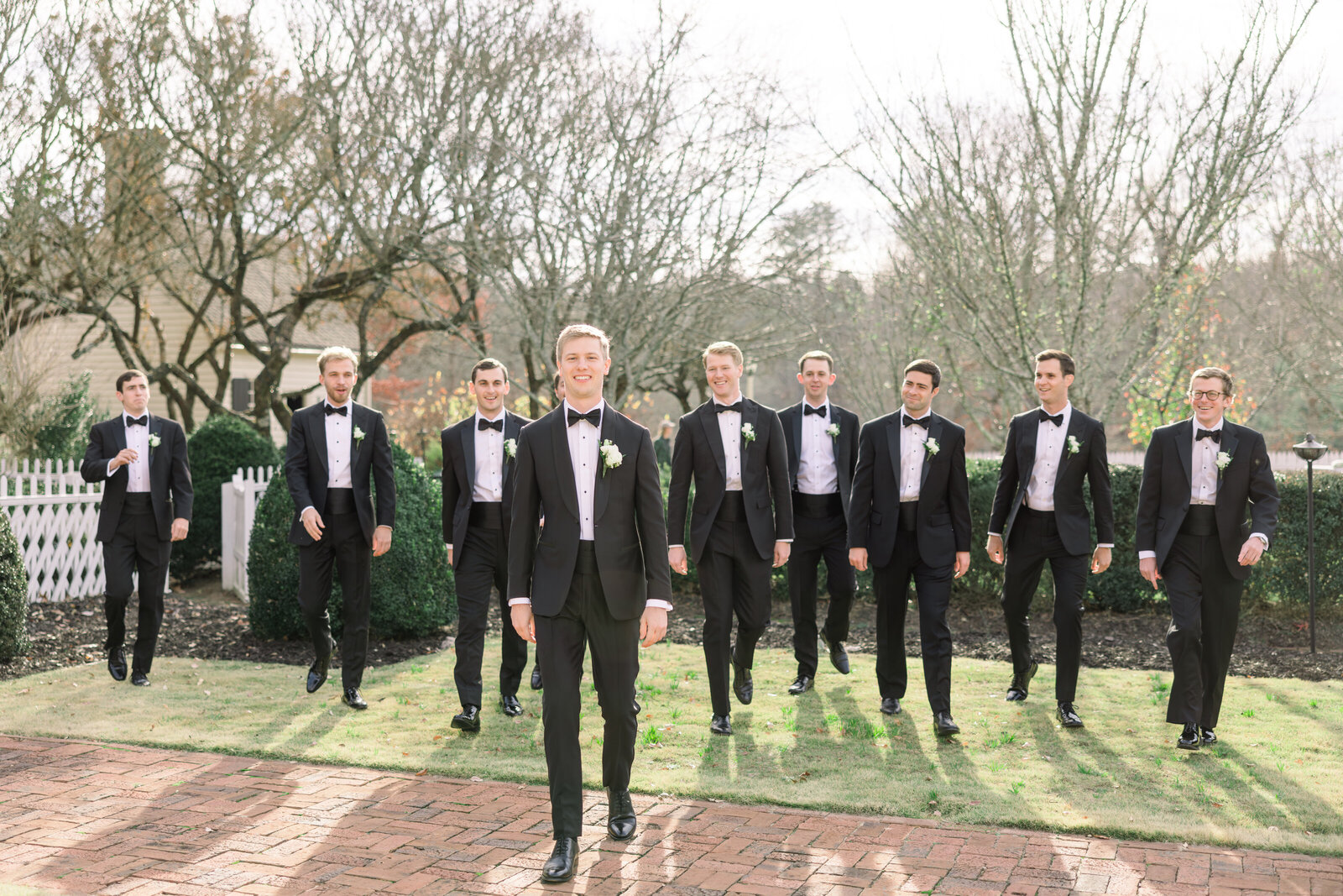 Groom and groomsmen pose in a mix of formal and playful moments at Inola in Blue Ridge, GA, celebrating friendship and camaraderie on the wedding day.