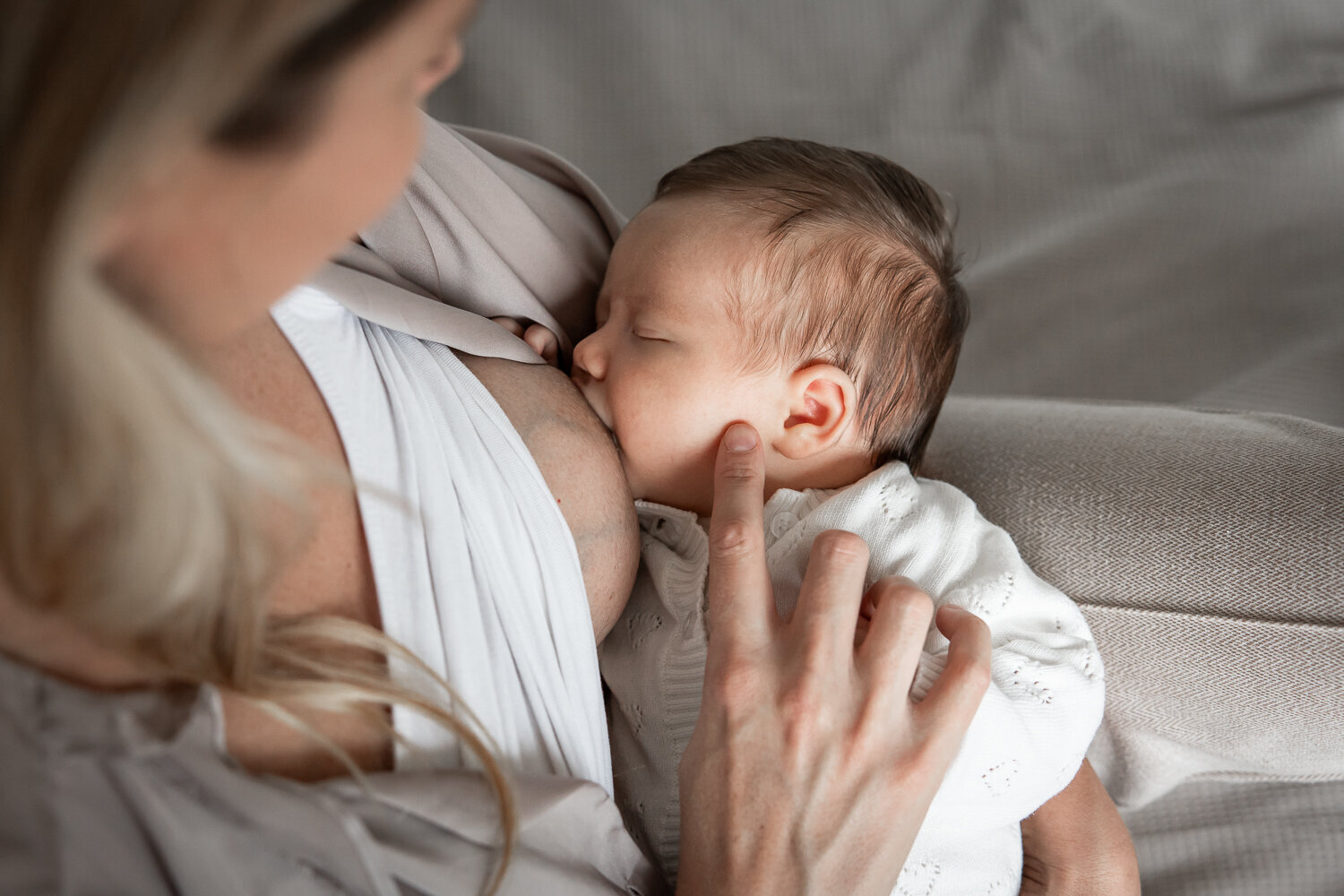 close up van borstvoedingsmoment. moeder aait haar baby. Newbornshoot thuis.