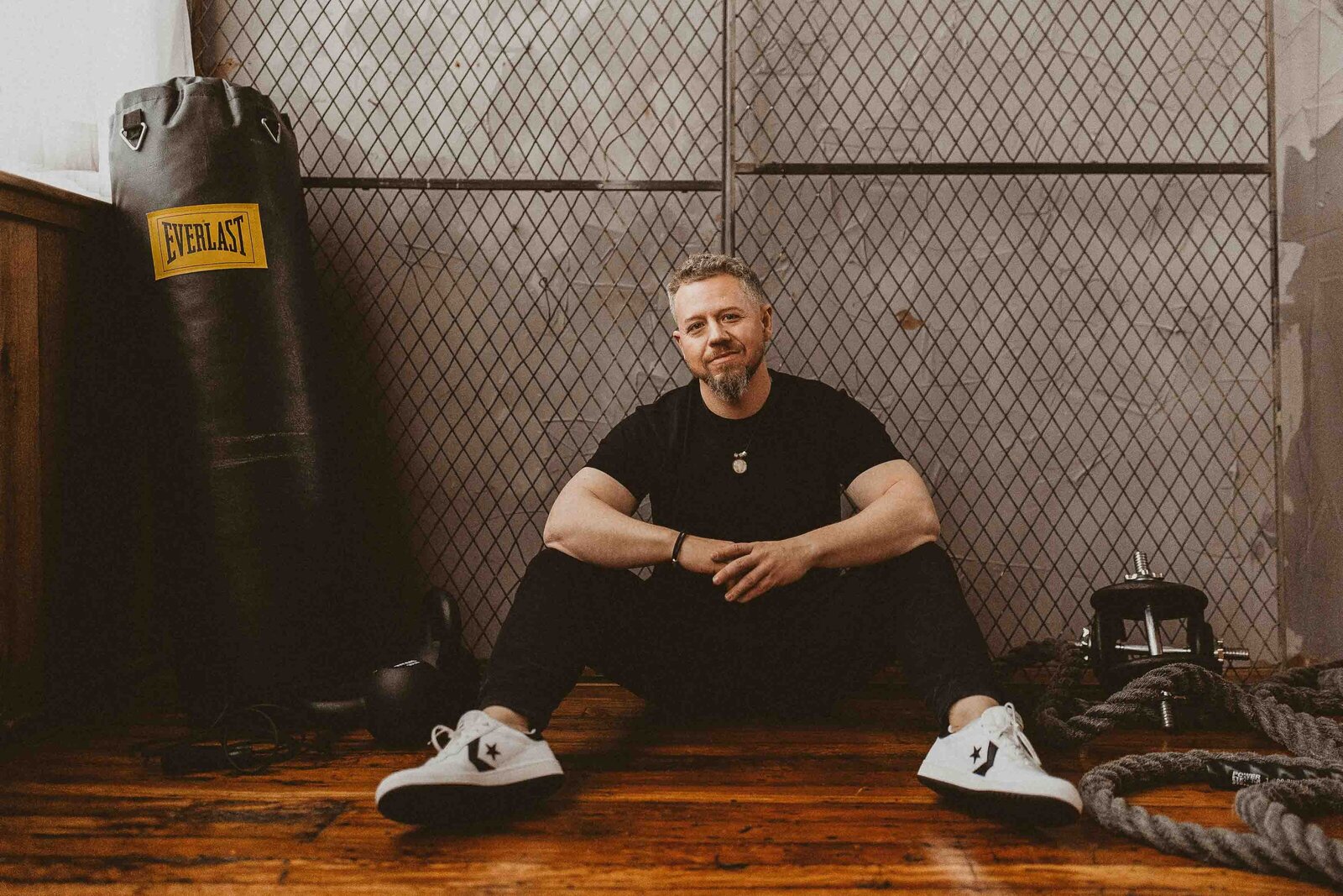 man sitting on the floor with gym accessories 