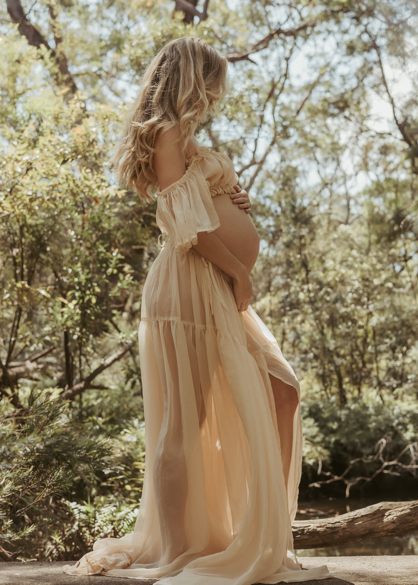 Blonde pregnant mum-to-be wearing a beige chiffon two piece set photographing her maternity journey in nature.