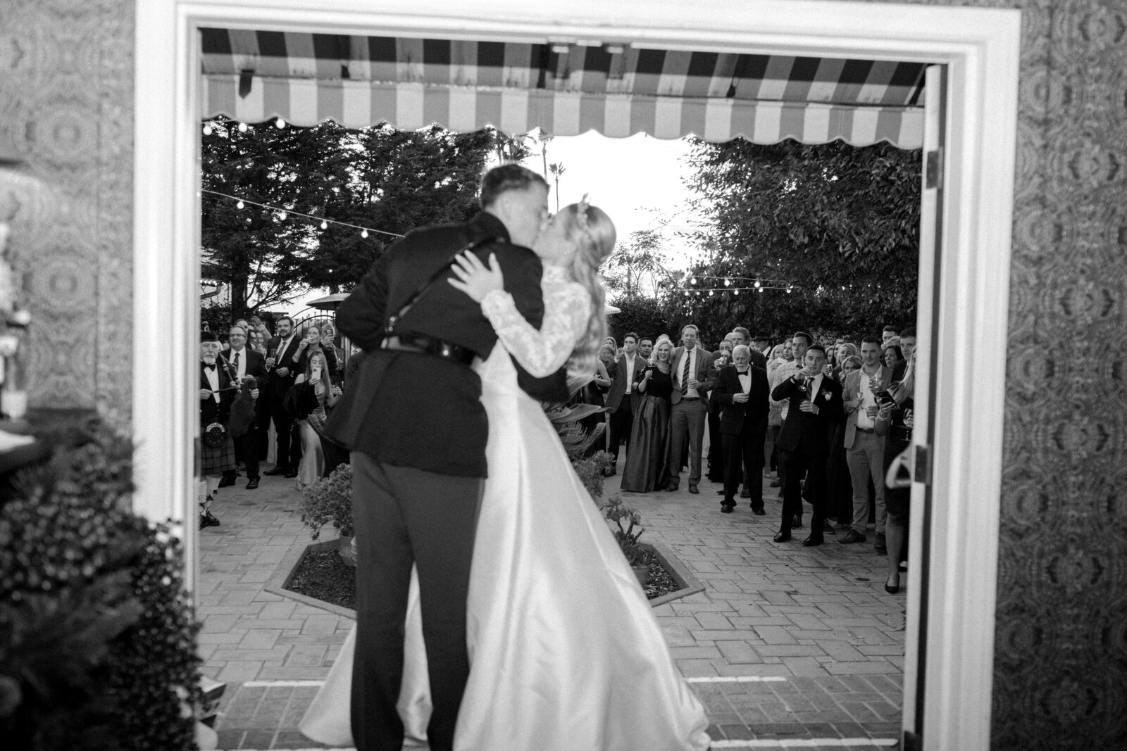 bride and groom share kiss as they enter their wedding party