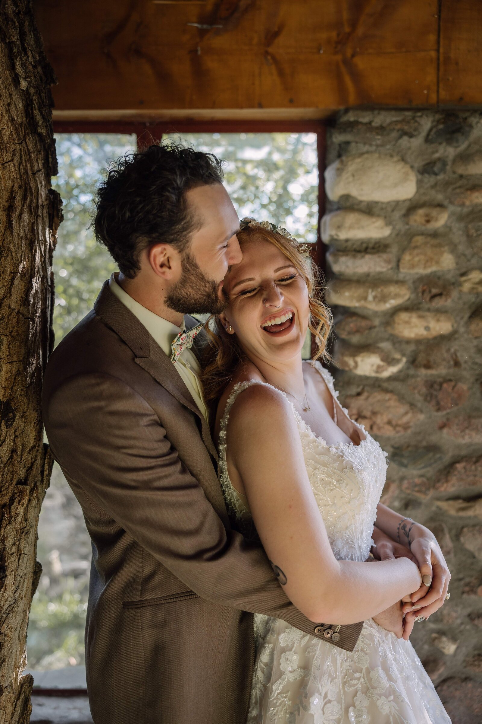 bride laughing in groom's arms