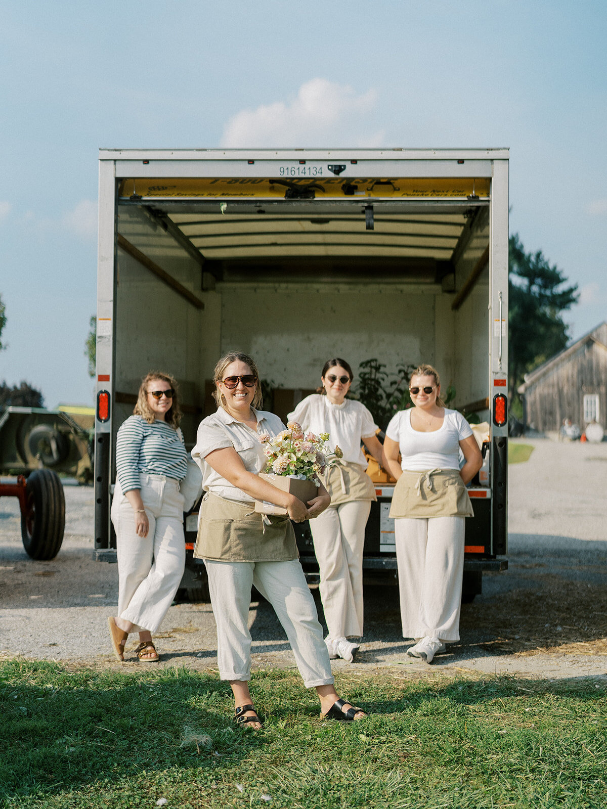 Floral Team dressed in beige and white in front of the truck.