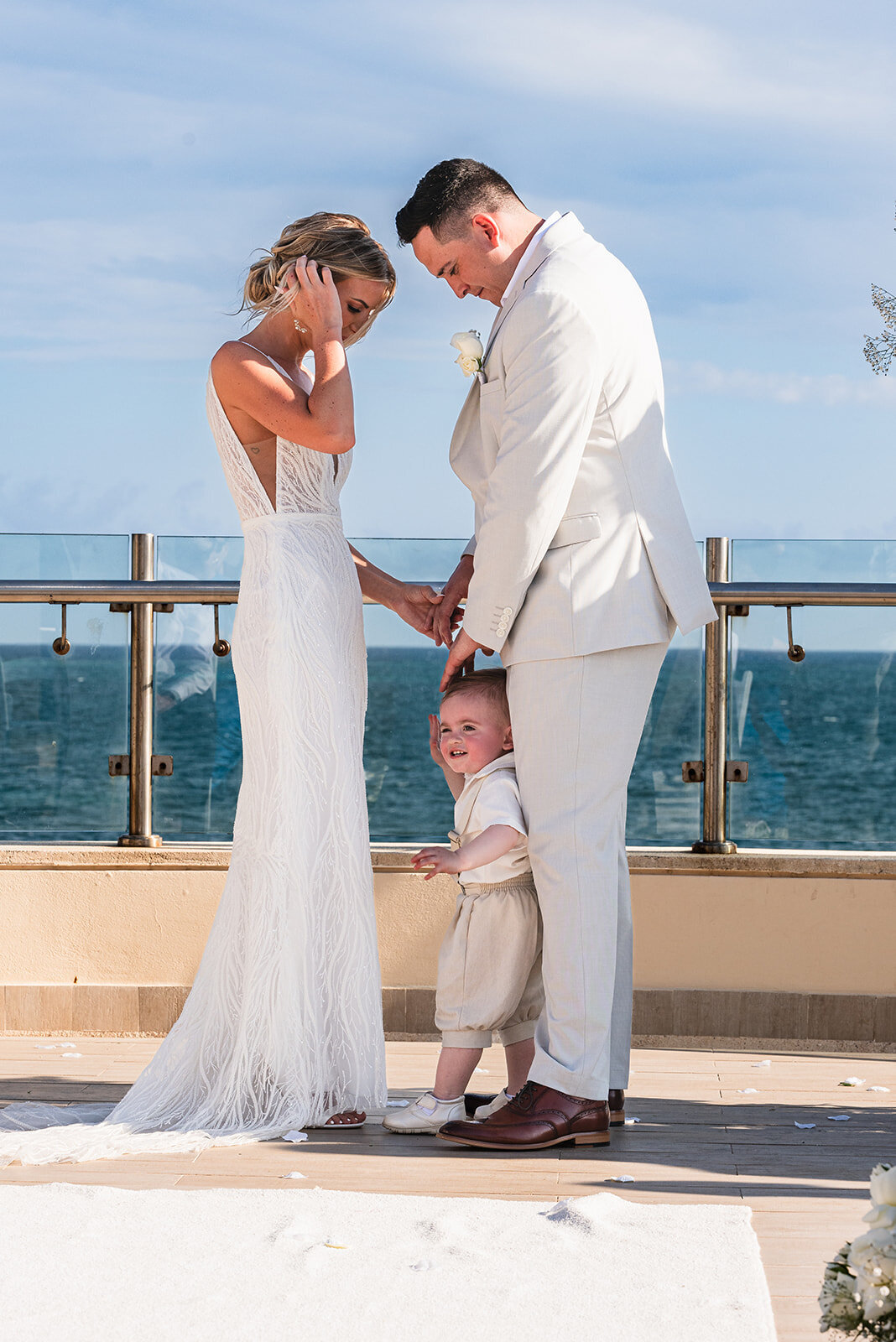 A romantic moment of the bride and groom standing together by the ocean after their wedding ceremony, captured by CMH Studios during a destination wedding
