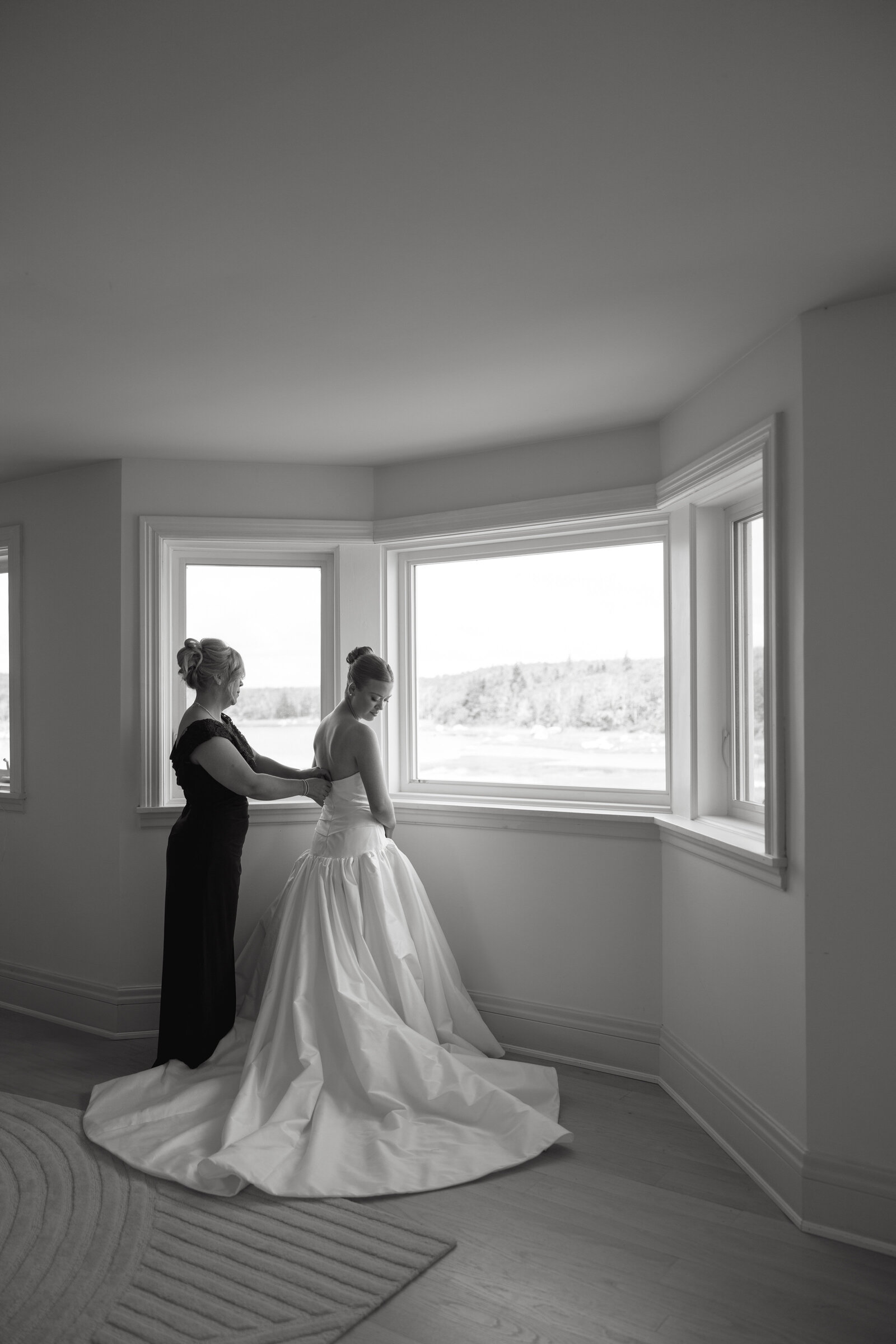 A mother zips up her daughter's wedding dress on her wedding day at Bullpoint Estate in Nova Scotia. 