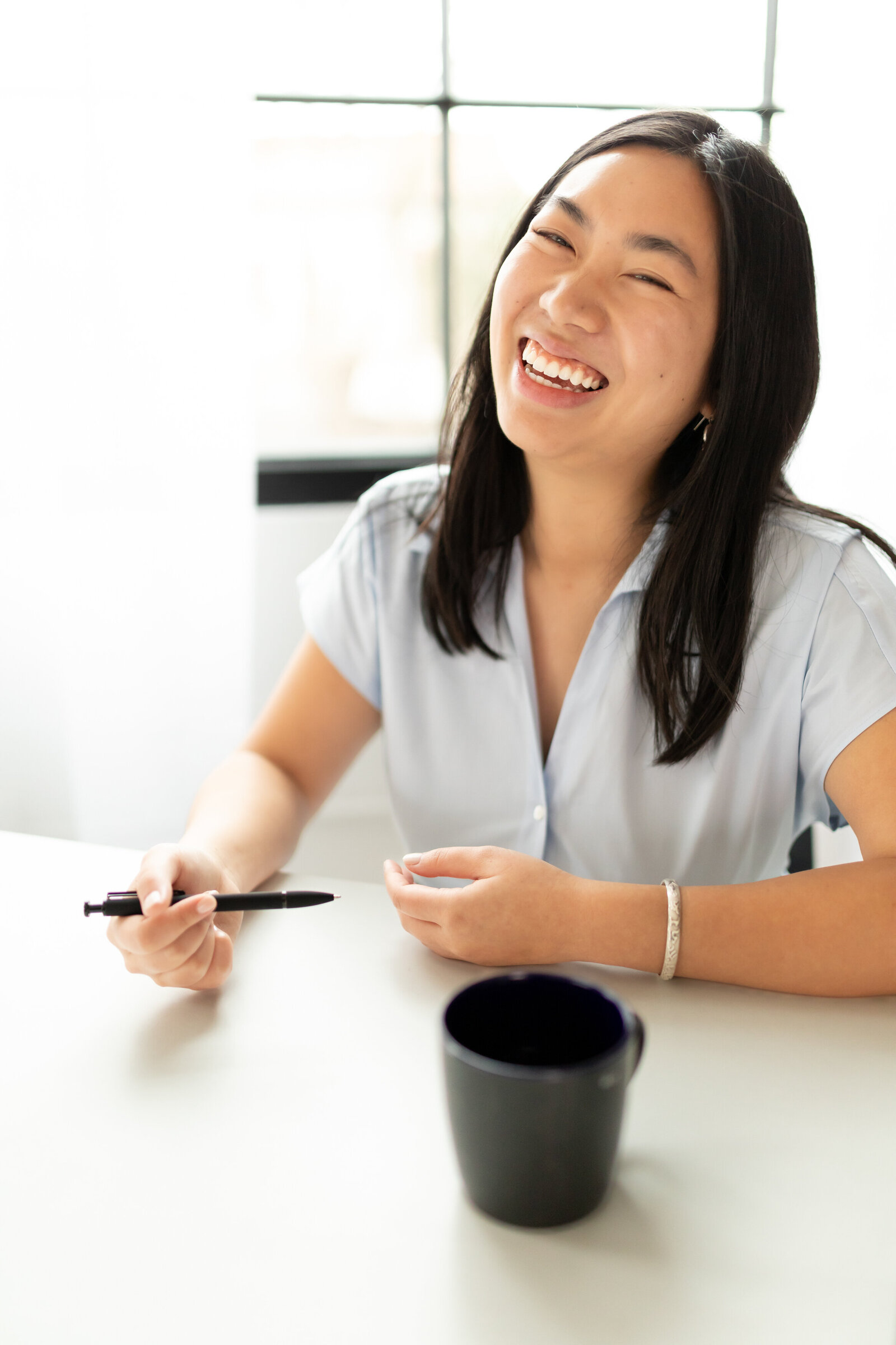 woman smiles and laughs at camera during branding session at studiostudio in ann arbor michigan