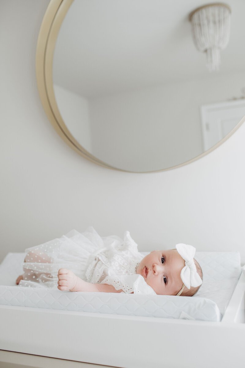 Newborn baby on bed looking at nj newborn photographer
