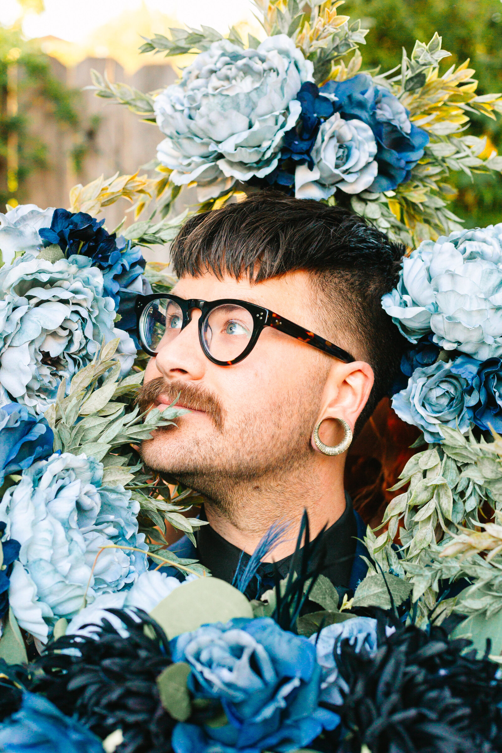 Tattooed groom with colorful wedding flowers.
