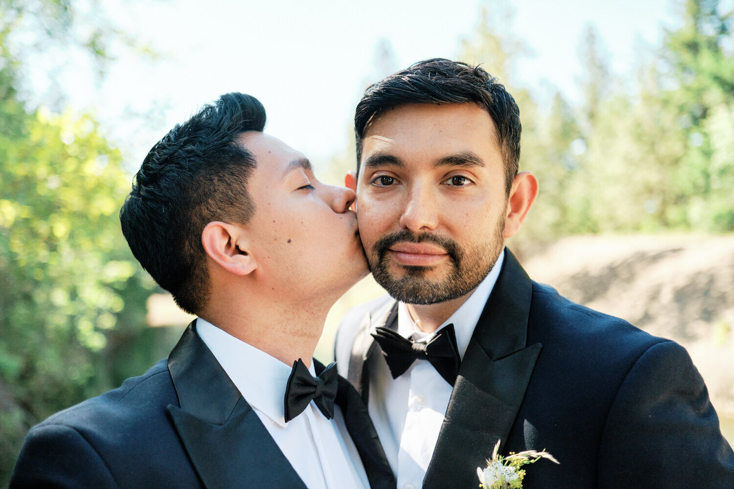 LGBTQ couple kiss on the cheek