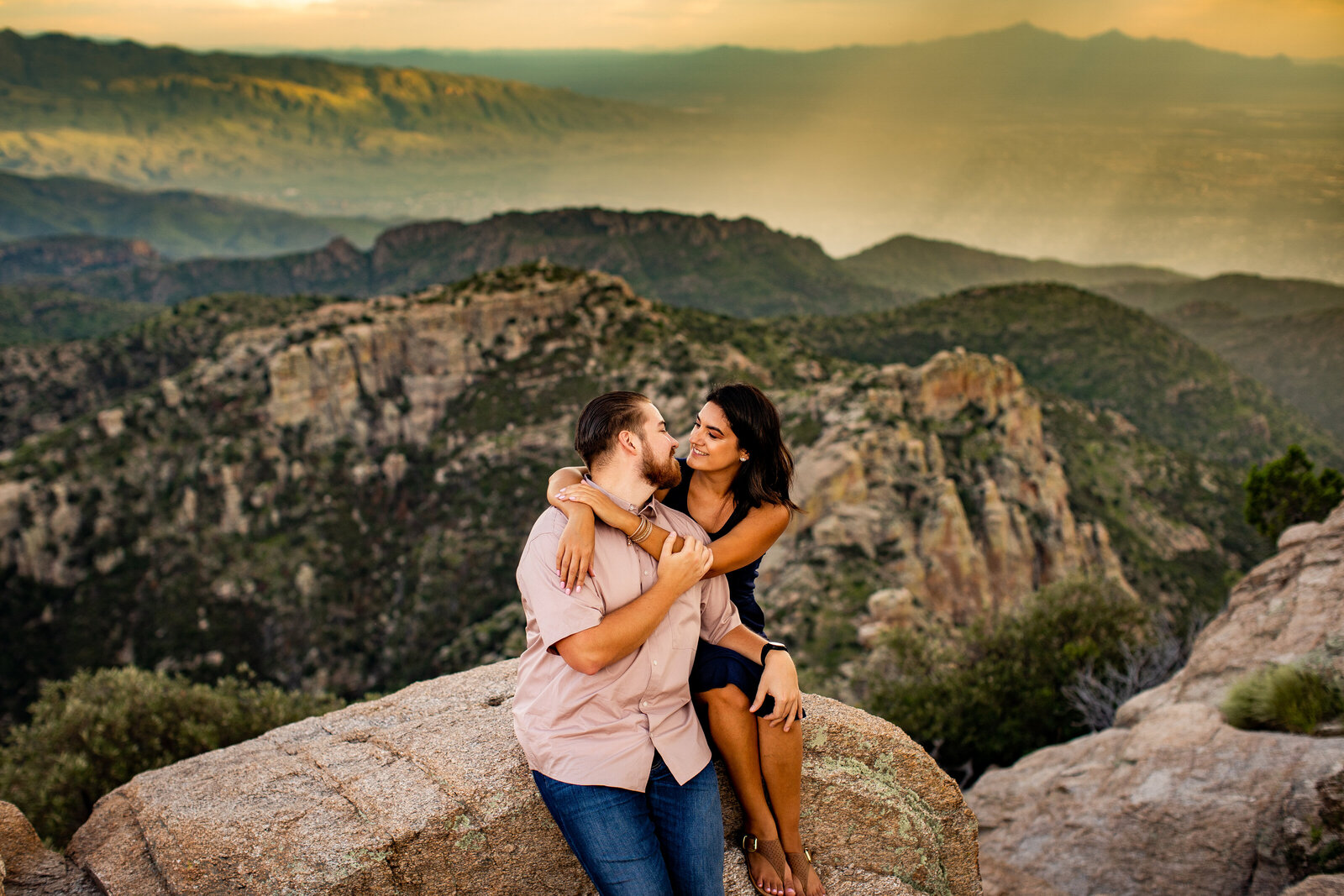 Mount Lemmon engagement photos couple sitting on rock at sunset